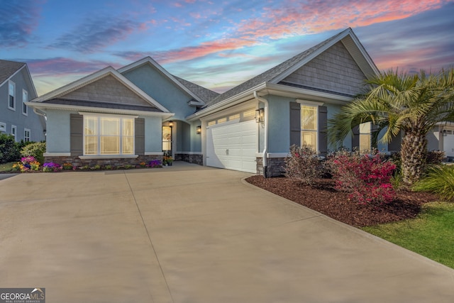 craftsman inspired home with stone siding, driveway, an attached garage, and stucco siding