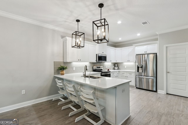 kitchen with light wood-type flooring, a peninsula, stainless steel appliances, and backsplash