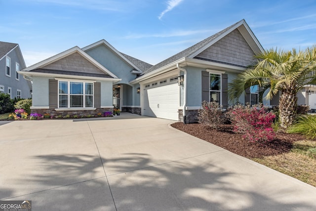 craftsman-style home featuring a garage, stone siding, concrete driveway, and stucco siding