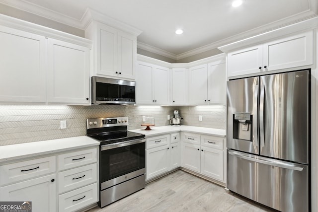 kitchen featuring stainless steel appliances, white cabinetry, ornamental molding, and decorative backsplash