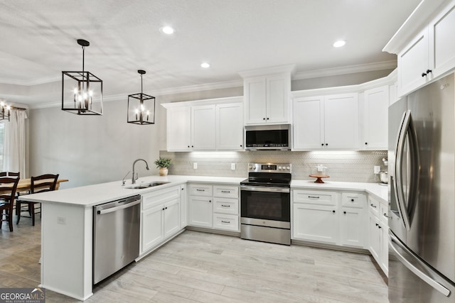 kitchen with stainless steel appliances, crown molding, a sink, and a peninsula