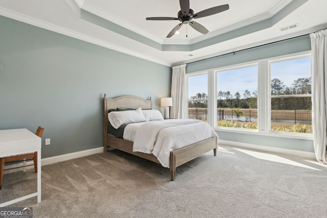 bedroom with baseboards, a raised ceiling, visible vents, and crown molding