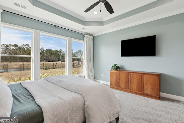 bedroom with crown molding, a raised ceiling, light colored carpet, visible vents, and baseboards