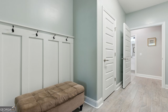 mudroom featuring light wood-style flooring and baseboards