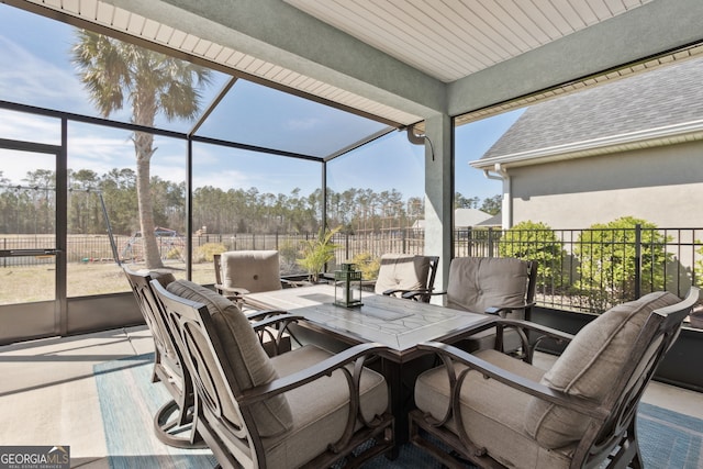 view of patio with glass enclosure and fence