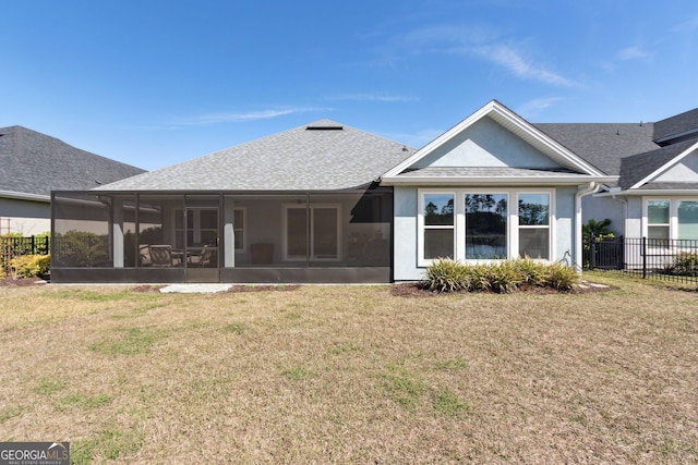 rear view of property with roof with shingles, a lawn, fence, and a sunroom