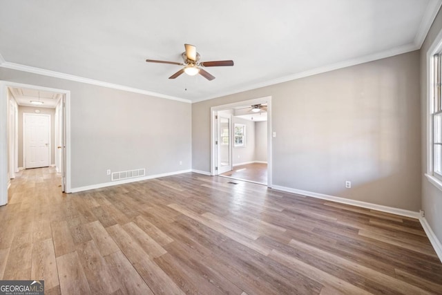 empty room with attic access, visible vents, baseboards, and wood finished floors