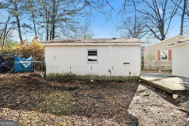 view of outbuilding featuring fence and an outbuilding