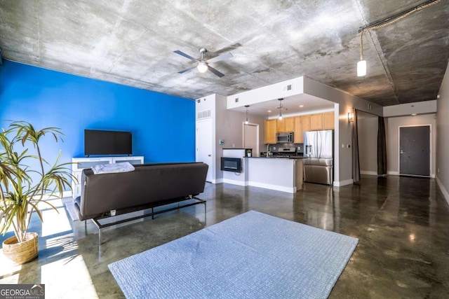 living room featuring concrete floors, visible vents, ceiling fan, and baseboards