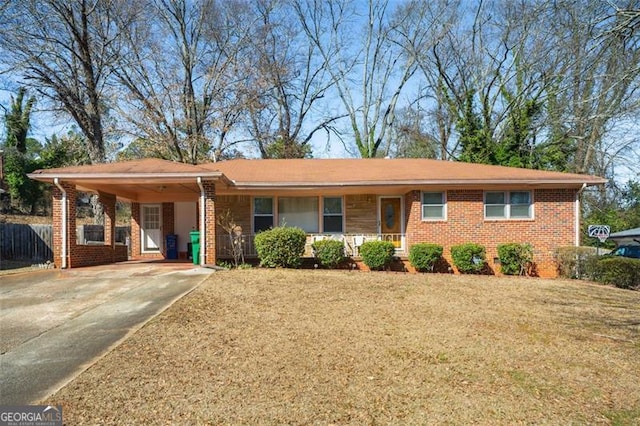 ranch-style home with brick siding, a front yard, fence, an attached carport, and driveway