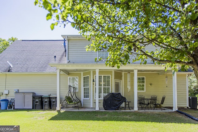 rear view of house featuring central AC unit, a patio, and a yard