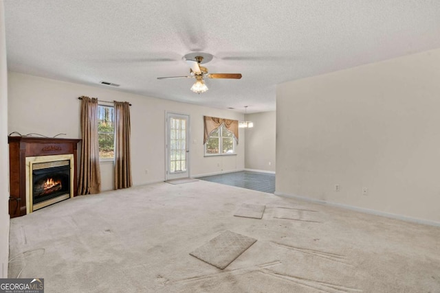 unfurnished living room with a ceiling fan, carpet, visible vents, and a glass covered fireplace