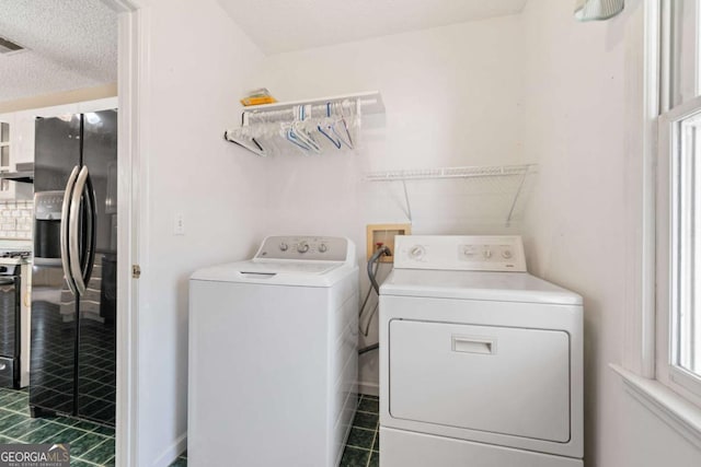 laundry area with a textured ceiling, laundry area, separate washer and dryer, and visible vents