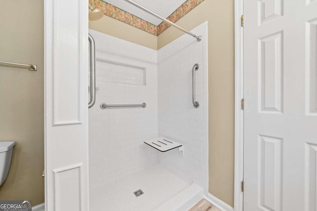 full bath featuring a shower stall and toilet