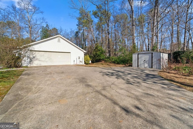 view of side of home featuring a garage, a shed, and an outbuilding