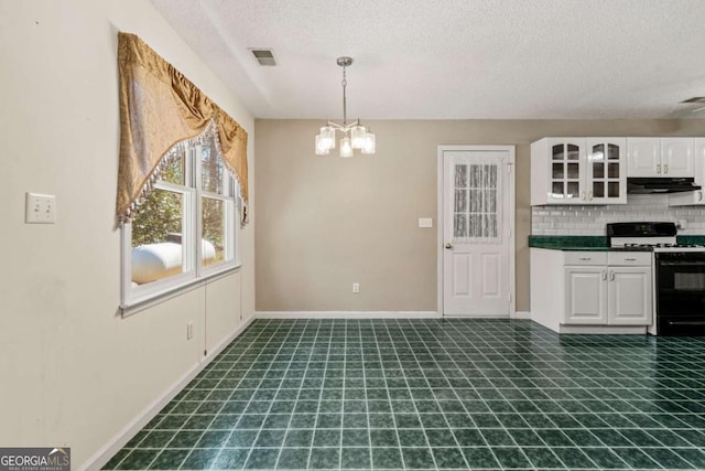 interior space featuring a chandelier, visible vents, a textured ceiling, and baseboards