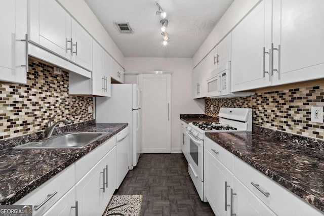 kitchen with white appliances, a sink, visible vents, and white cabinetry