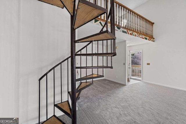 stairs with a high ceiling, baseboards, and carpet flooring