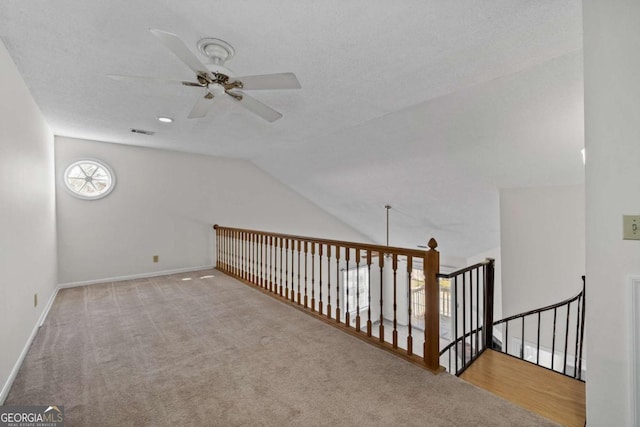 additional living space with visible vents, carpet flooring, vaulted ceiling, ceiling fan, and baseboards