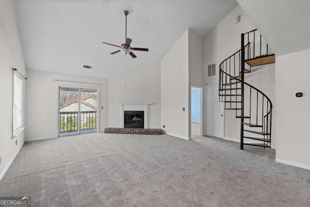 unfurnished living room featuring high vaulted ceiling, visible vents, a fireplace, and carpet flooring