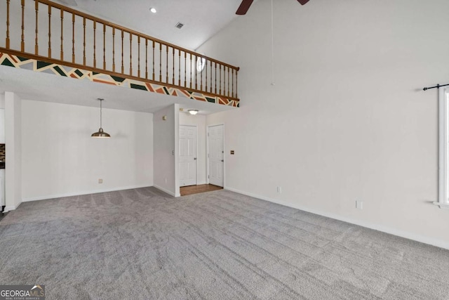 unfurnished living room featuring high vaulted ceiling, carpet floors, visible vents, a ceiling fan, and baseboards