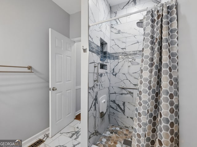 bathroom featuring marble finish floor, visible vents, a marble finish shower, and baseboards