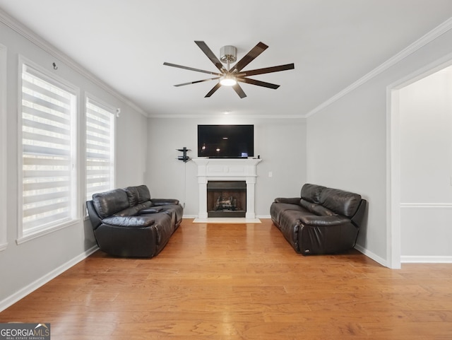 sitting room featuring ornamental molding, light wood-type flooring, a fireplace with flush hearth, and baseboards