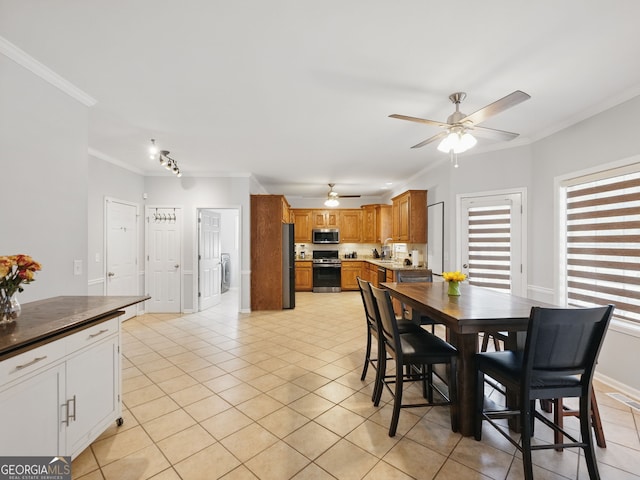 dining space featuring ornamental molding, ceiling fan, baseboards, and light tile patterned floors