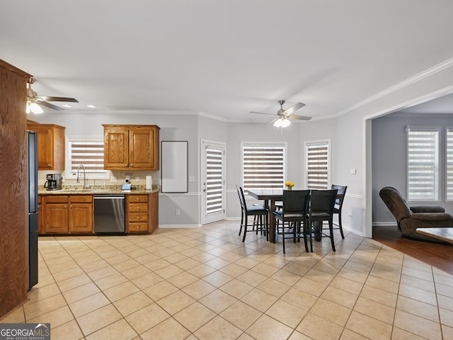 kitchen featuring light tile patterned floors, brown cabinets, crown molding, stainless steel dishwasher, and a sink