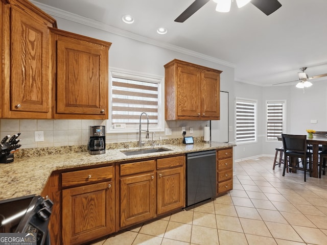 kitchen with brown cabinets, light tile patterned floors, stove, a sink, and dishwashing machine