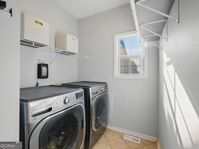 laundry area featuring light tile patterned flooring, laundry area, visible vents, baseboards, and independent washer and dryer