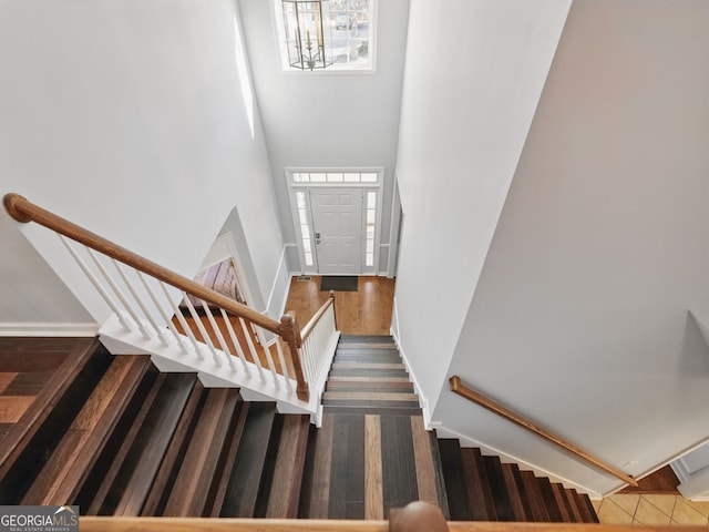 stairs with a towering ceiling and baseboards