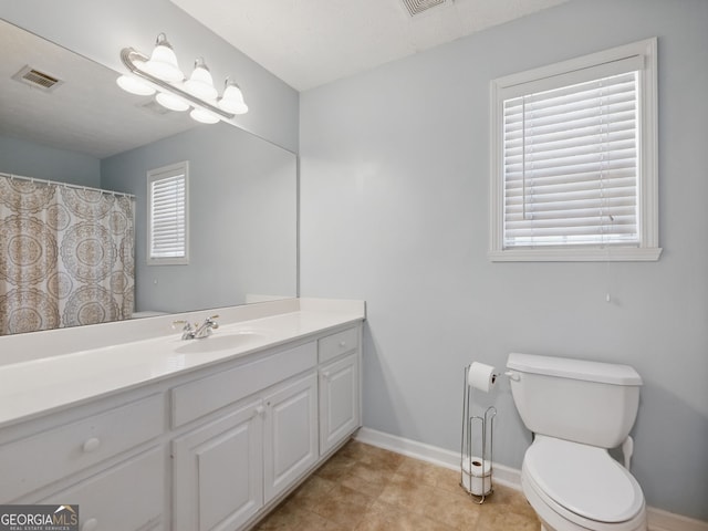 full bathroom with toilet, vanity, visible vents, and baseboards