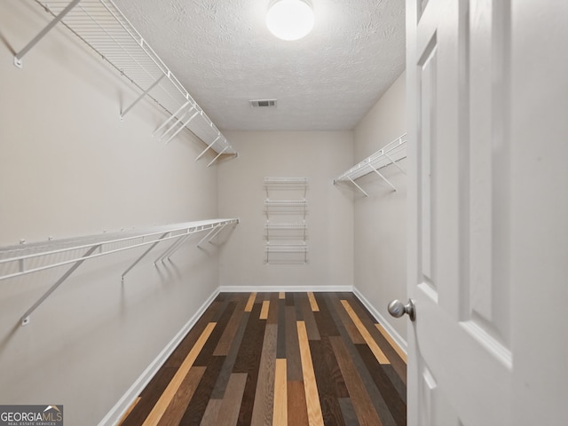 walk in closet with visible vents and wood finished floors