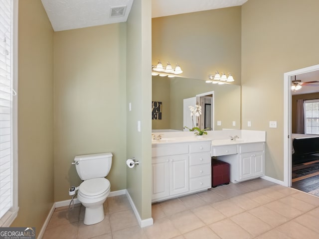 bathroom featuring visible vents, toilet, a sink, baseboards, and tile patterned floors