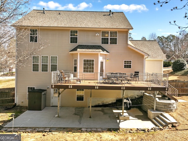 back of house featuring a shingled roof, a patio area, fence, and a wooden deck