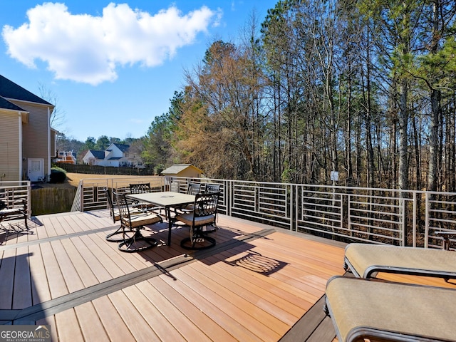 deck with an outbuilding and outdoor dining space