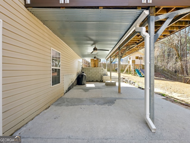 view of patio featuring a playground and fence