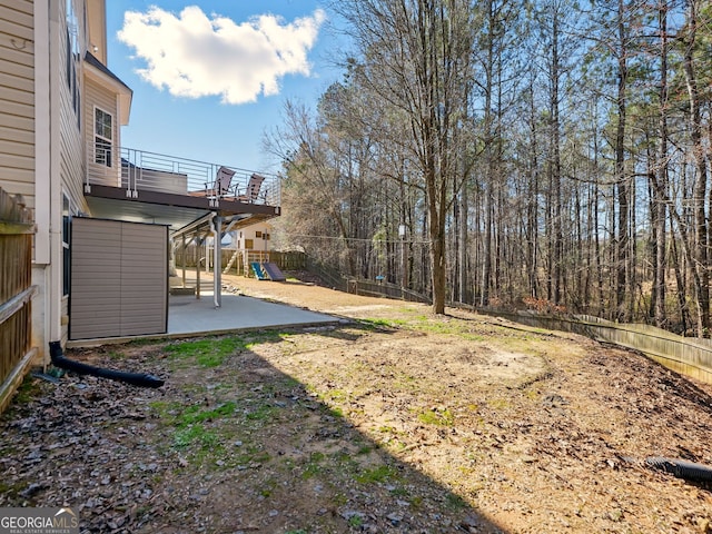 view of yard with a patio area, a playground, and fence