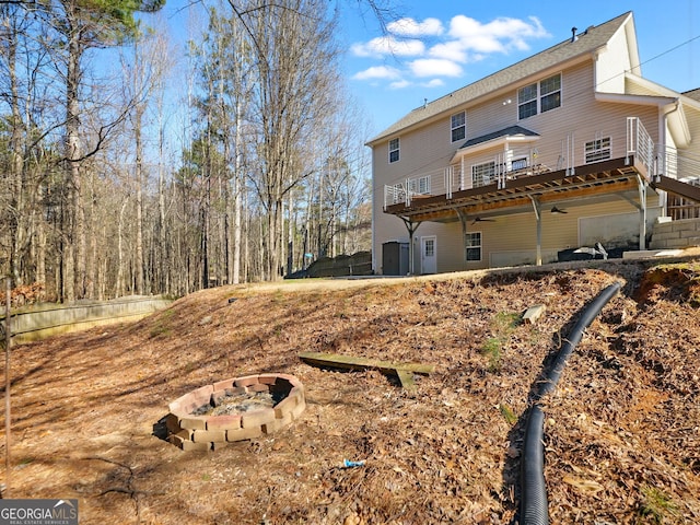 back of house featuring a deck and an outdoor fire pit