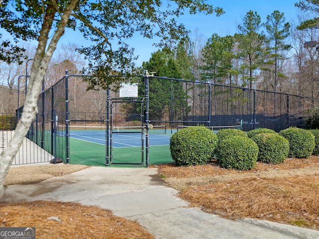 view of sport court with a gate and fence