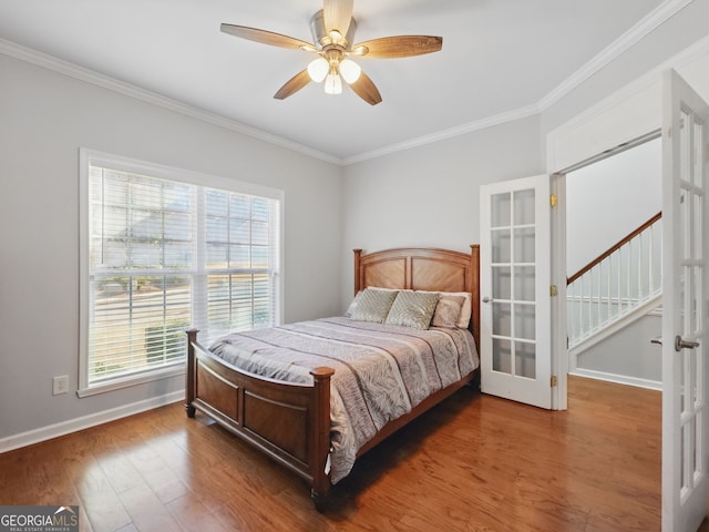 bedroom with baseboards, ornamental molding, wood finished floors, and french doors