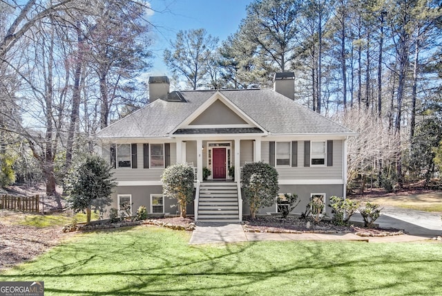 view of front of home featuring fence, a chimney, a front lawn, and stucco siding