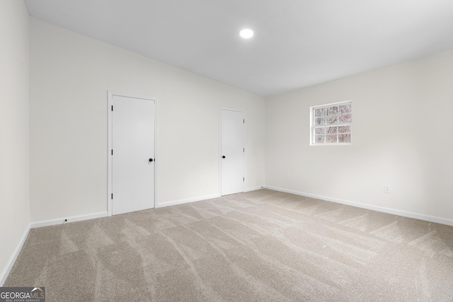 carpeted spare room featuring recessed lighting and baseboards