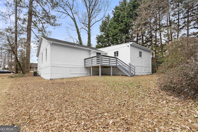 back of property featuring stairs and a deck