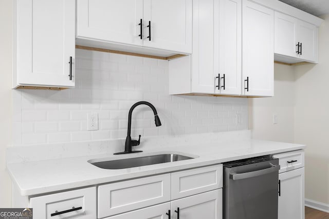 kitchen featuring light stone counters, a sink, white cabinets, decorative backsplash, and dishwasher