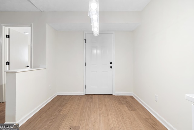 unfurnished room featuring light wood finished floors and baseboards