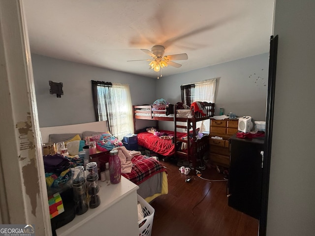 bedroom with a ceiling fan, multiple windows, and wood finished floors