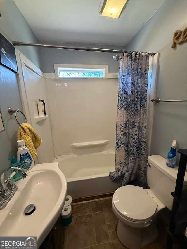 full bath with toilet, shower / bath combination with curtain, a sink, and tile patterned floors