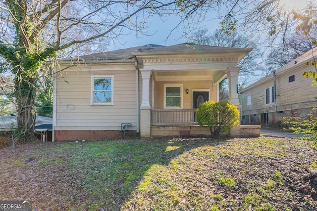 rear view of property with a porch and a yard